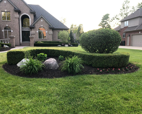 Full landscape maintenance in Shelby Township, MI including mulch, bush trimming, flowers, and lawn care