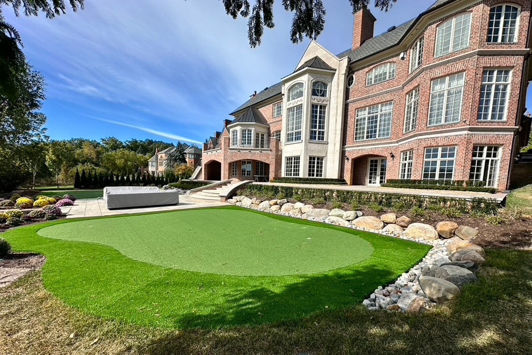 An artificial turf backyard putting green installed by J & J Landscaping at a high-end residential property in Metro Detroit