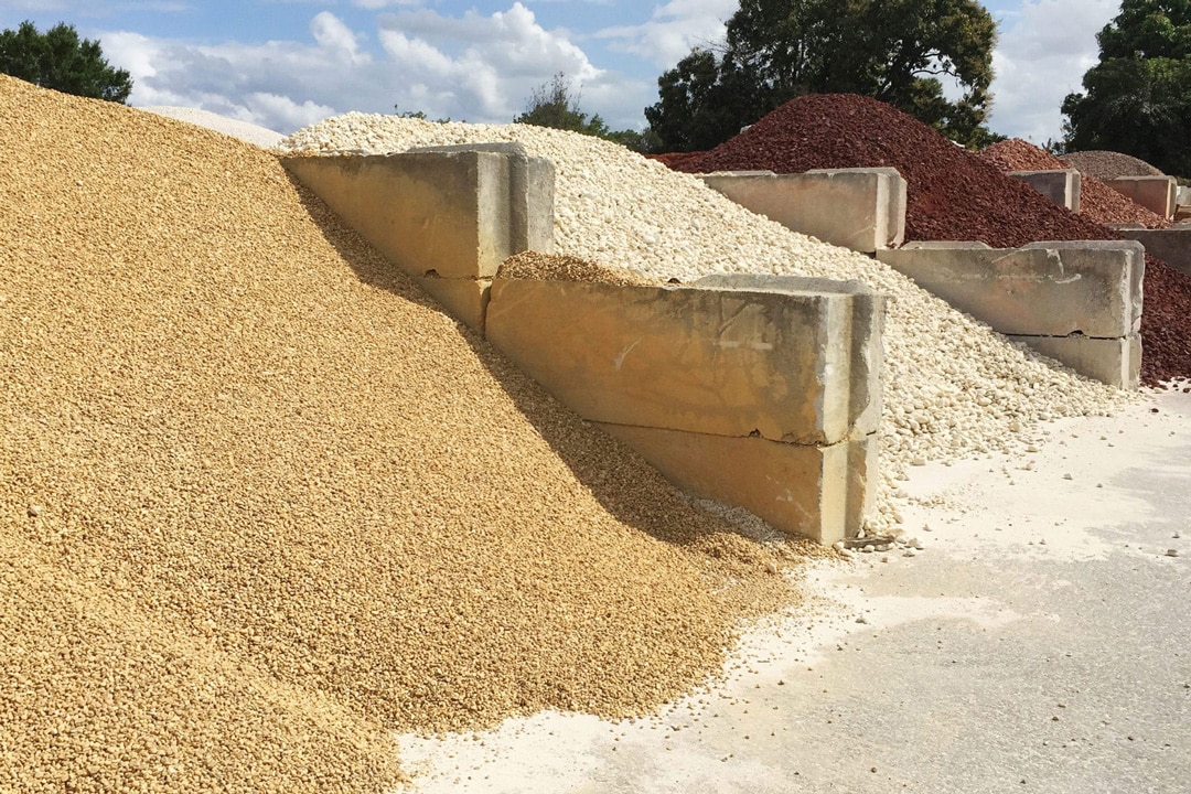 Large piles of gravel, stones, and mulch ready for new landscaping and hardscaping projects