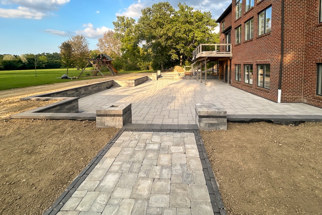 A high-end residential brick paver retaining wall and patio designed and built by J & J Landscaping in Metro Detroit