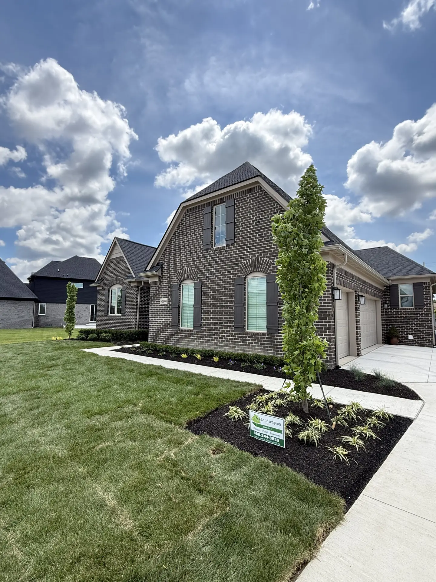 A landscape with two columnar trees designed and installed by J & J Landscaping in Shelby Township, Michigan.