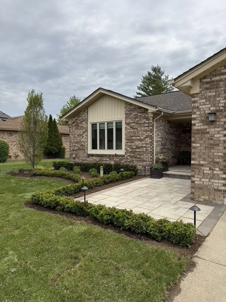 A front paver walkway and landscaping designed and installed by J & J Landscaping at a residential home.